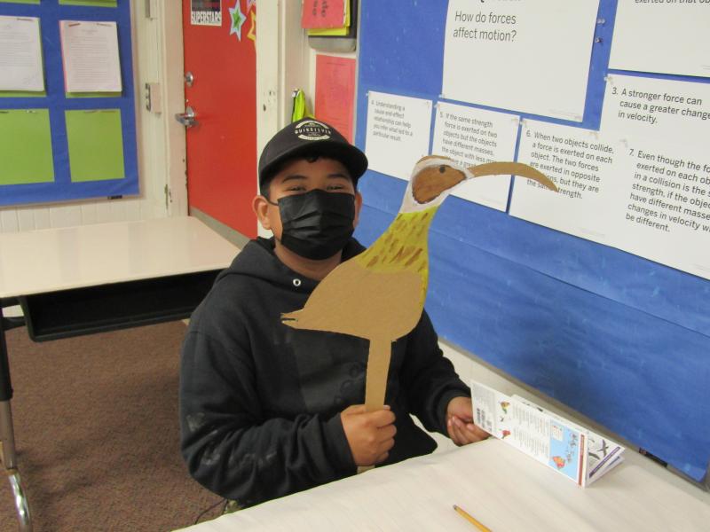 Classroom scene of student with art project from Coastal Camp.