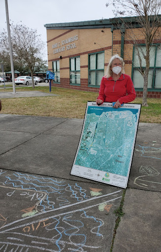 Educator with map, student drawings