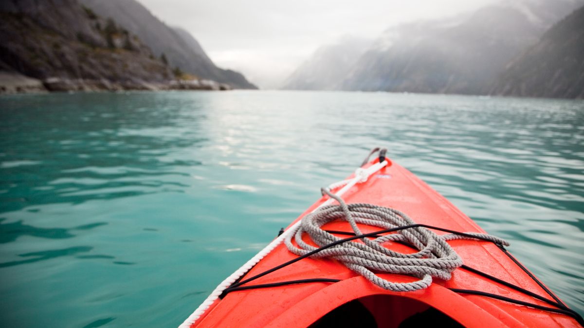 red kayak in glacier water alaska
