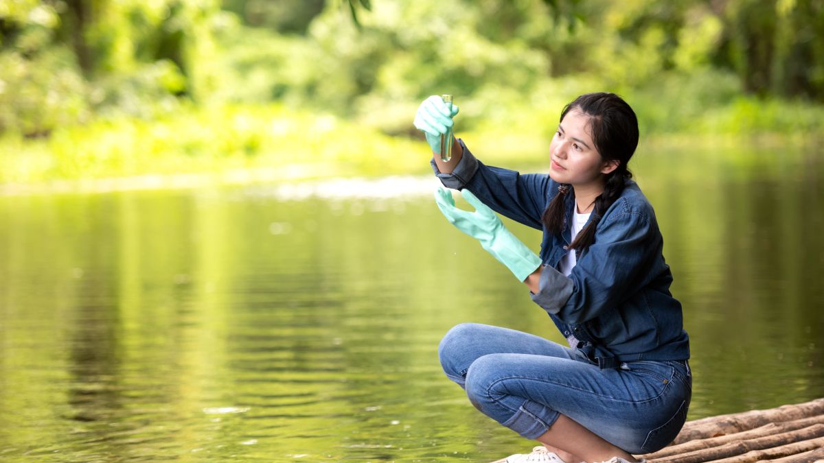 Woman testing water at river edge