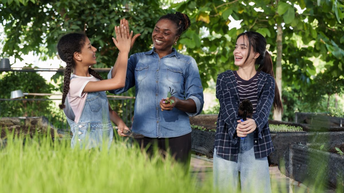 Three people high-fiving outdoors