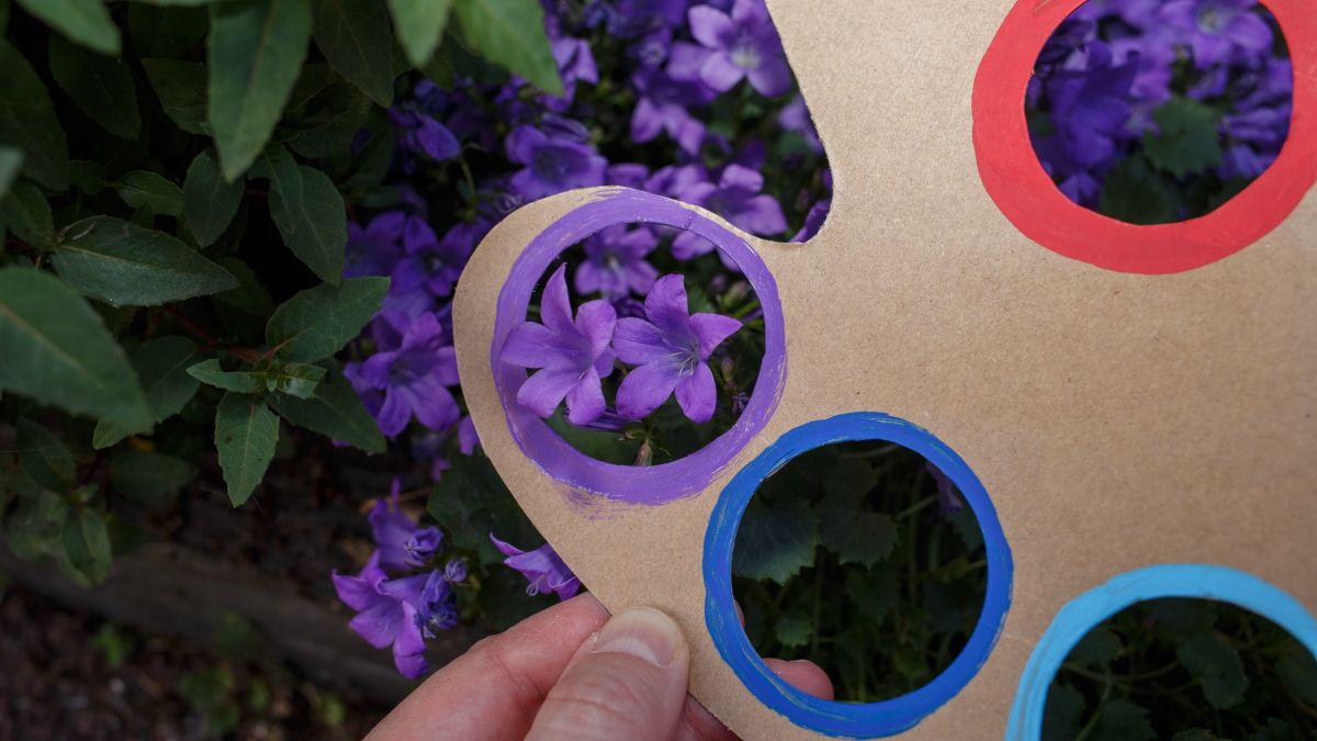 Cardboard cut to represent an artist's pallette with a purple flower