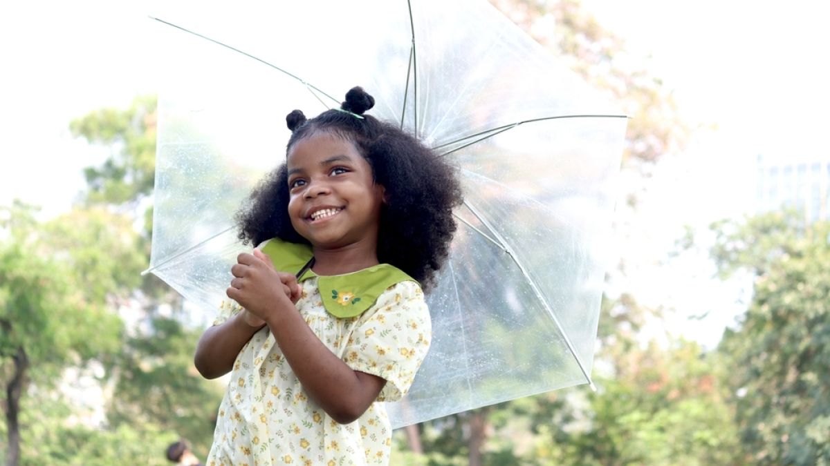 young black girl holding an umbrella