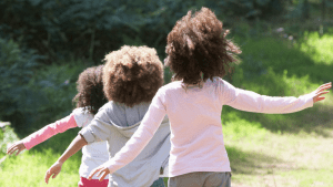 Three young children walking on a nature path