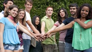 A group of young adults putting their hands together
