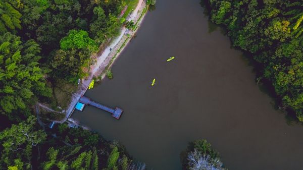 An aerial view of a river with bright yellow canoes 