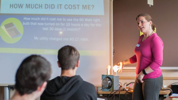 AK EnergySmart teacher Photo of teacher with LED and incandescent bulbs, photo by Tim Leach