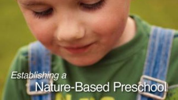 A child in overalls holds a toad