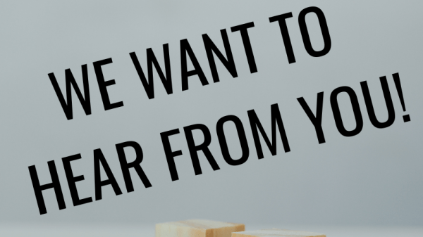 Text reads "We Want to Hear from You!"; gray background with three wooden cubes with faces on them: one frowning, one neutral, one smiling
