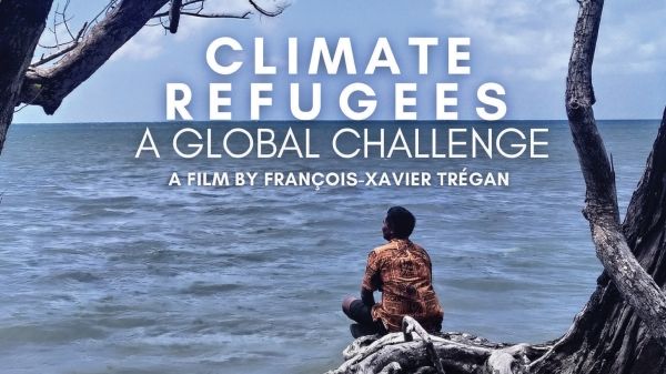 Climate Refugees: A Global Challenge poster, showing a person sitting on some driftwood overlooking the ocean and a cloudy sky