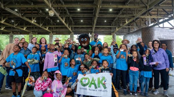 A class of 4th graders gather for a group photo to celebrate the Every Kid Outdoors Program with mascot, Buddy the Bison, and other local leaders and national champions of the EKO program at an event in Anacostia Park sponsored by OAK.