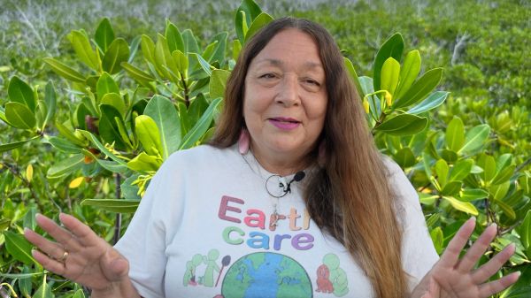 Gail Woon talking about EARTHCARE near a mangrove tree