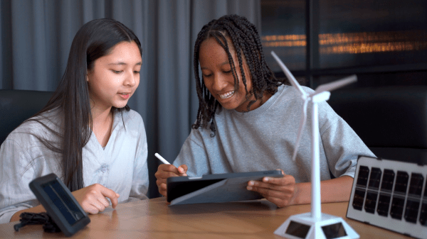 Green Careers: Curriculum Toolkit Supplement Group of high school students learning and discussing about renewable energy science with windmill turbine model together in classroom, a science student learning about sustainable energy science.