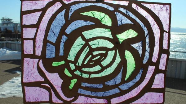 Sea Turtle Art A tissue paper suncatcher depicting a green sea turtle in a blue circle on a purple background