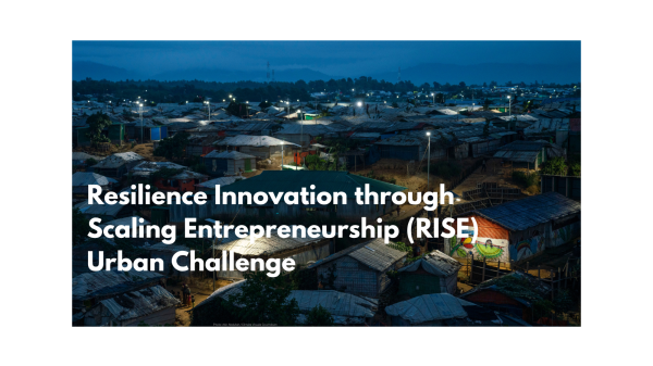 Resilience Innovation through Scaling Entrepreneurship (RISE) Urban Challenge Text on an image of a crowded urban settlement at night: "Resilience Innovation through Scaling Entrepreneurship (RISE) Urban Challenge".