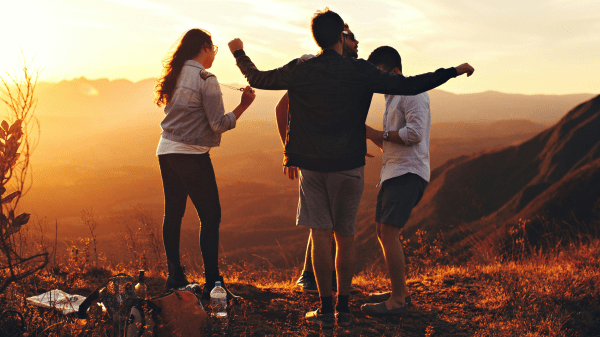Social Aspects of Sustainability Can’t Be Forgotten Four people facing away from the camera against a hilly sunset background