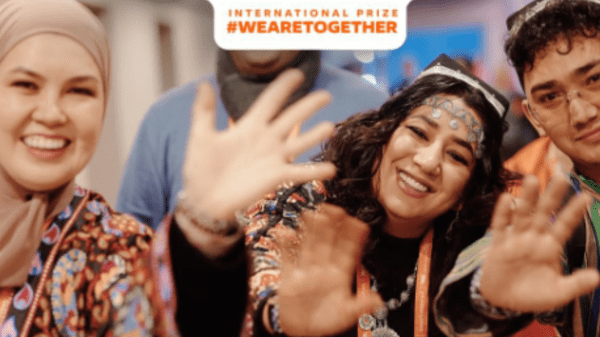 A banner announcing the 2026 We are Together Prize showing volunteers waving and smiling