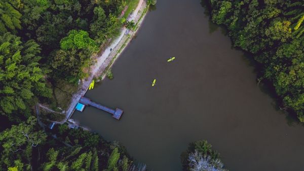 An aerial view of a river with bright yellow canoes 