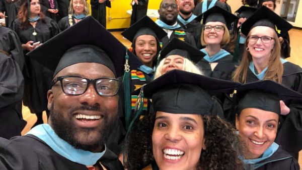 Photo of a group of smiling people wearing caps and gowns
