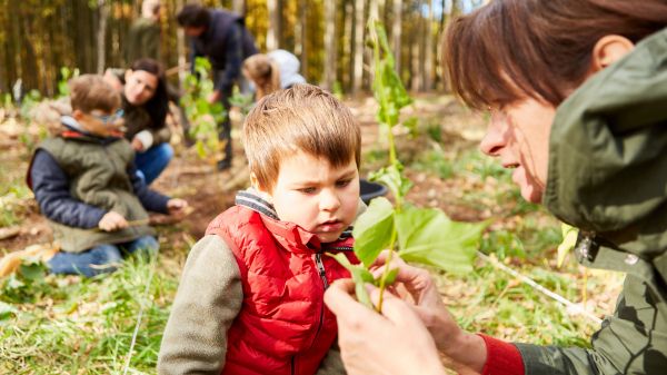 young child outdoors learning about plants