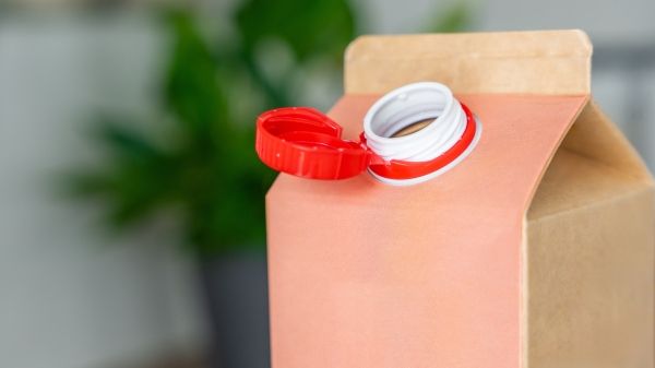 A red carton with an open lid, a blurred room background behind it.