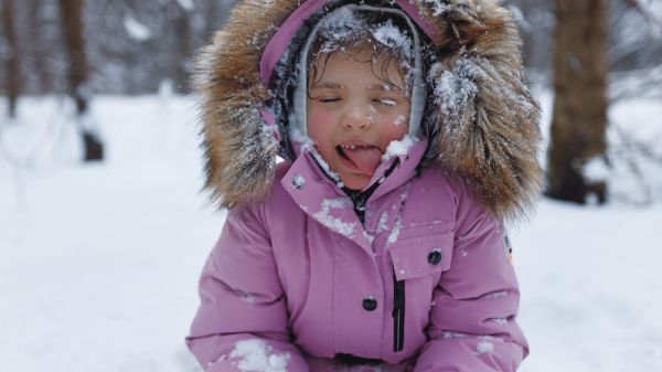 child in snow with tongue sticking out