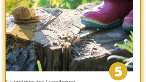 Close-up of pink rain boots standing near a snail