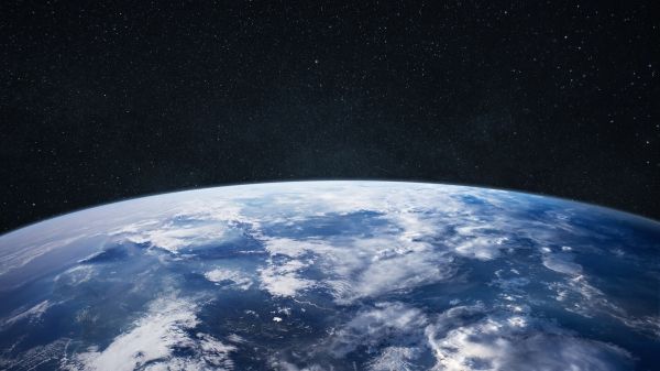 Amazing blue planet earth with ocean, clouds and continents in open space on the starry sky.