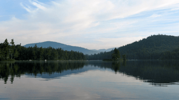 Mountains and a lake under a blue sky with some clouds
