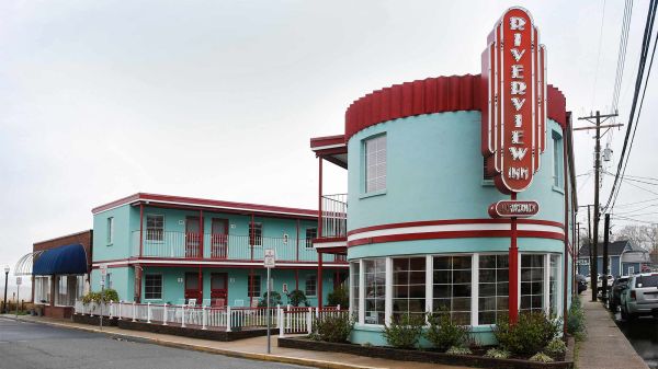 Photo of a blue inn with a retro facade on the corner of a street