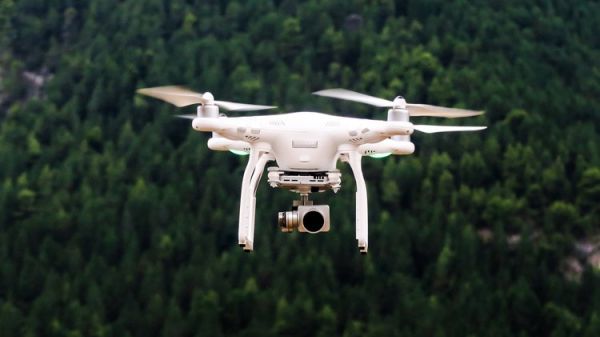 Photo of a drone flying above a forest