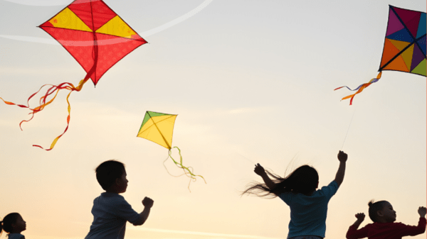 Silhouette of kids playing with kites