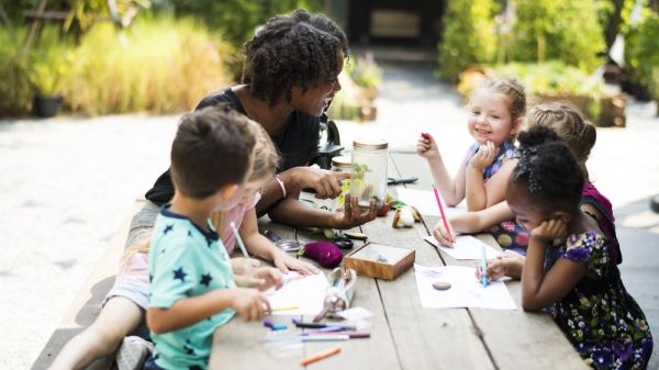 educator with young children outside working on nature art