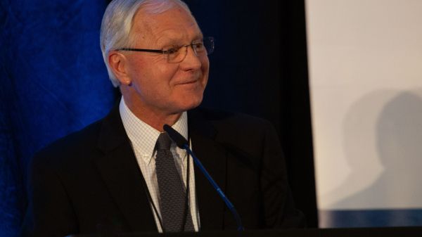 John Flciker smiling at a podium