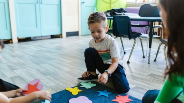 Boy in Gray Crew Neck T-shirt Playing With Blue and Red Puzzle Mat