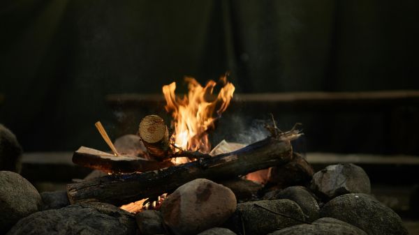 Campfire A small campfire sits in the center of rocks against a dark background