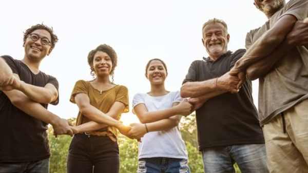 A group of people standing in a half-circle formation holding each other's hands