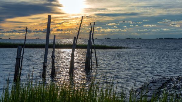 sun peaking through clouds over chesapeake bay