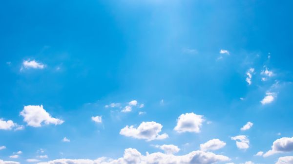 white clouds at horizon against blue sky