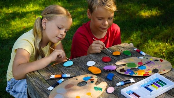 Pair of children painting rocks