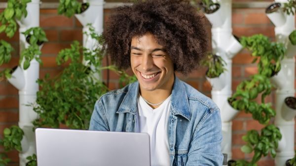 Young man smiling at his laptop