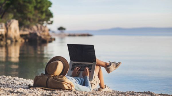 Woman on beach with laptop