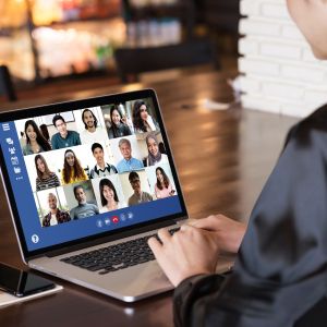 Person using laptop for zoom call with multiple participants.