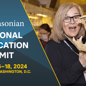 Blond woman smiling next to a fossil