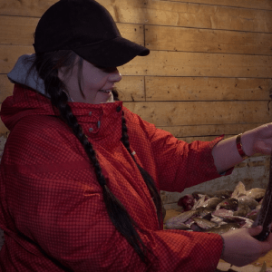 Picture of Ocean School's youth host Holly examining a cod fish