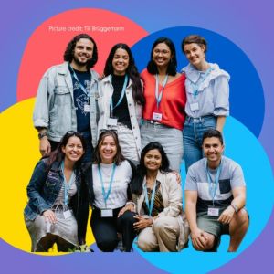 Group of smiling students in fron tof four colorful overlapping circles set against a purple background