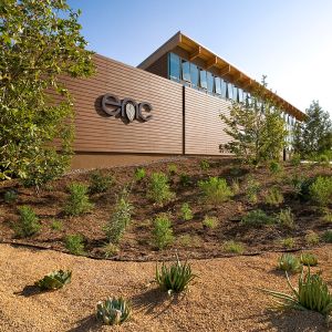 A building on a sunny day. The letters "enc" are posted on the building. Landscaping with desertous plants in front.