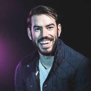 Esteban Gast has a broad smile, dark hair and beard. 