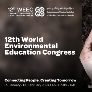 Brown background with white text on the left and a photo of a pair of hands holding some soil and a seedling. The white text says, "12th World Environmental Education Congress."
