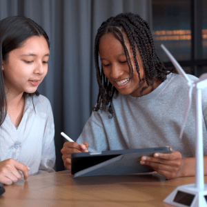 Group of high school students learning and discussing about renewable energy science with windmill turbine model together in classroom, a science student learning about sustainable energy science.